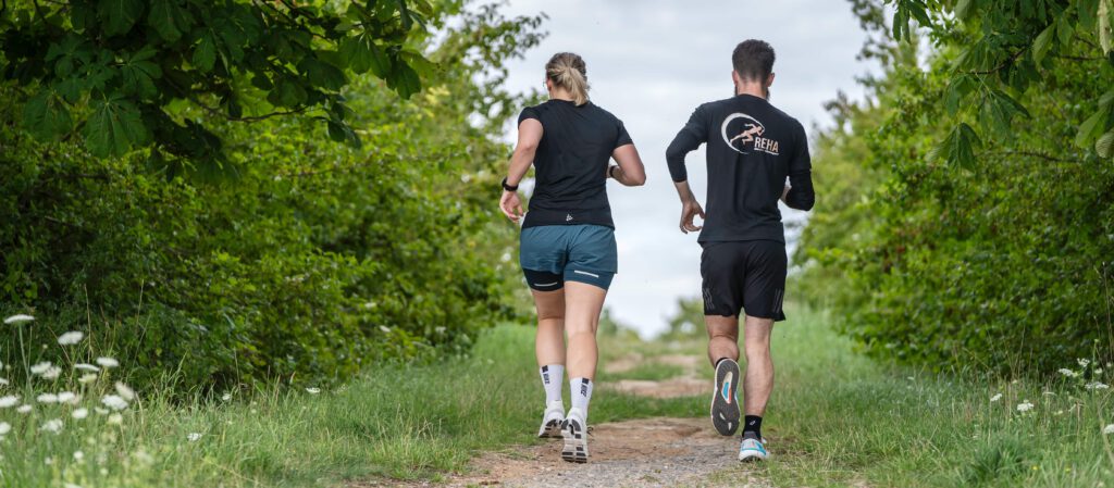Zwei Läufer beim Lauftraining im Sommer im Grünen – Warm-up und Vorbereitung für ein gesundes und effektives Sommertraining