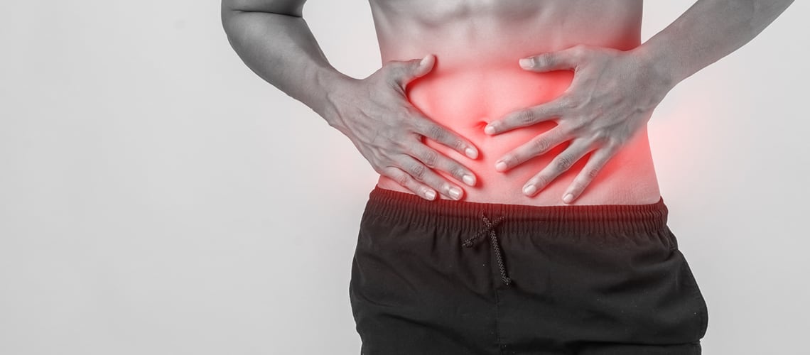 Mann hält sich den Bauch, Symbolbild für Darmbeschwerden und Entzündungen im Körper.