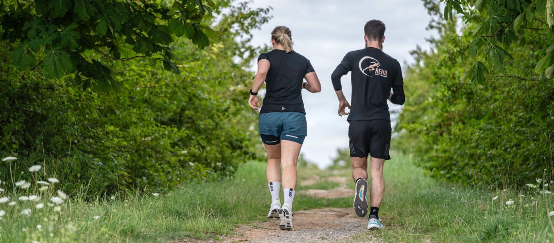 Zwei Läufer beim Lauftraining im Sommer im Grünen – Warm-up und Vorbereitung für ein gesundes und effektives Sommertraining